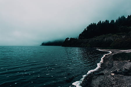 calm body of water near mountain thumbnail