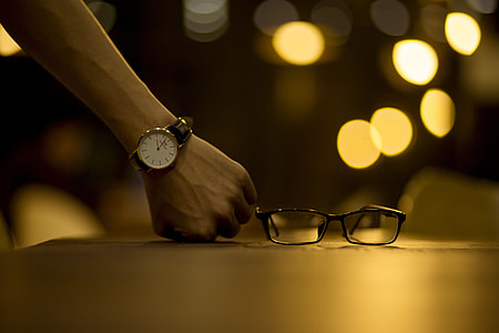 person resting fist beside eyeglasses thumbnail