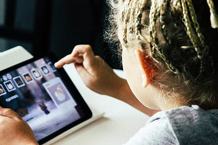girl holding tablet leaning on table thumbnail