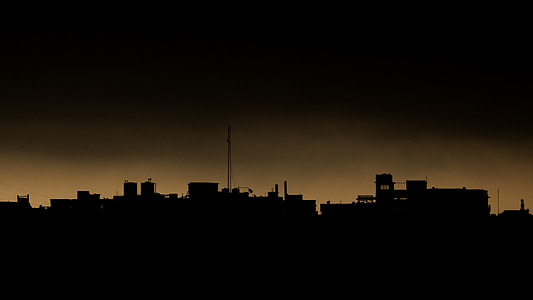 silhouette of concrete structures under gray sky thumbnail