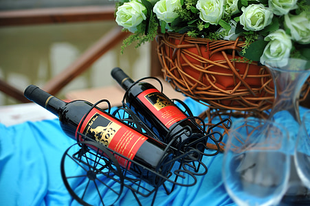 two black wine bottles in black metal racks thumbnail