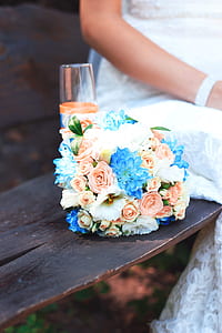 white, peach-colored, and blue flower bouquet on brown wooden bench thumbnail