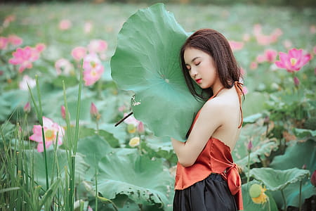 Woman Wearing Halter-neck Top Holding  Leaf thumbnail