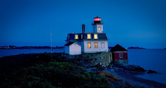 white and blue painted house beside body of water during nighttime thumbnail