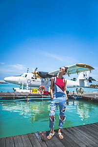 woman wearing distressed blue denim overalls standing on dock thumbnail