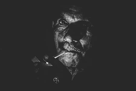 gray scale photo of man smoking cigarette thumbnail