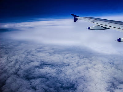 gray airplane floating above gray clouds thumbnail