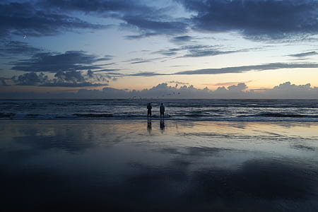 two people standing near ocean waves thumbnail