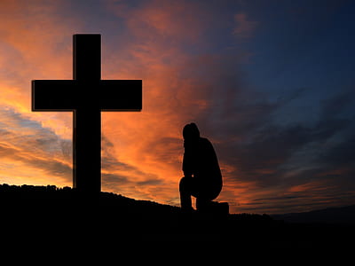 silhouette of person sitting in front of cross thumbnail