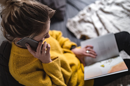 Young woman reading a magazine in bed thumbnail