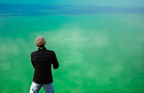 Man in Black Jacket Standing in Front of Sea thumbnail