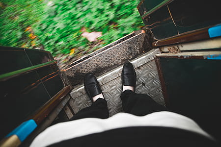 Looking down at feet on the edge of an open entrance door of a running train in Myanmar thumbnail