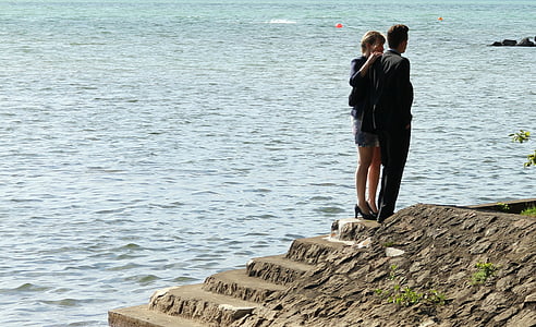 man and woman standing on stairs near body of water during daytime thumbnail