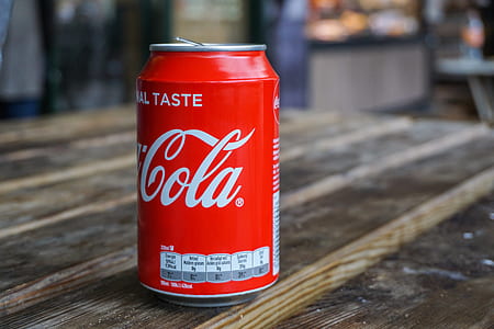 Coca-Cola drinking can on brown wooden table thumbnail