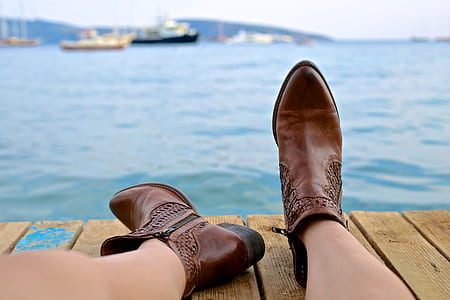 woman wearing pair of brown leather pointed-toe booties sitting on brown ship dock thumbnail