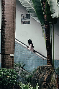 woman on stair holding stair rail during daytime thumbnail