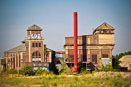 red pole on front of two brown concrete buildings thumbnail