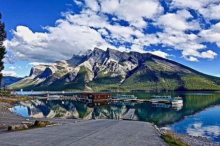 boats on body of water near mountain thumbnail