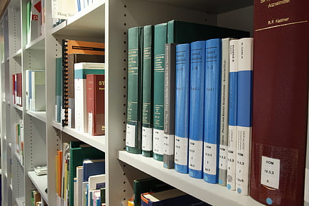 educational books on white wooden shelf thumbnail