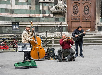 three man playing instruments on street thumbnail