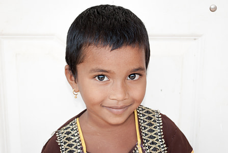 toddler in brown top beside white wall thumbnail