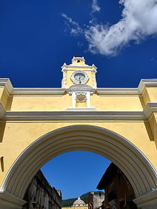 yellow and white concrete arch under blue and gray skies thumbnail