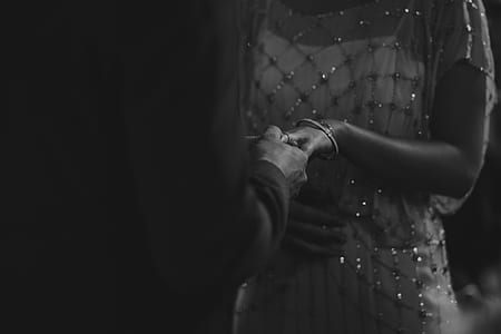 greyscale photo of man holding woman's hand thumbnail