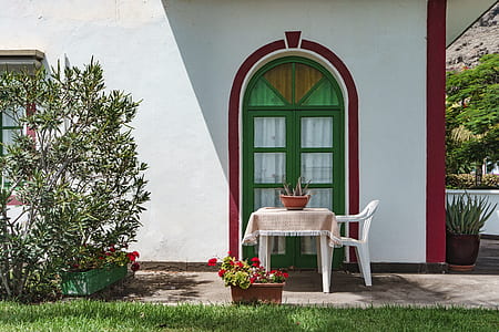 white table and chair near door surrounded with green grass at daytime thumbnail