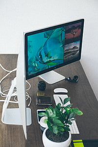turned-on flat screen monitor on brown wooden surface thumbnail