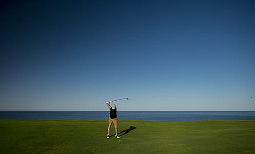 person in black top playing golf thumbnail