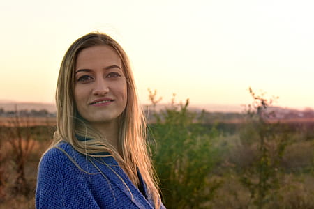 Woman in Blue Knit Top Smiling Outdoors thumbnail