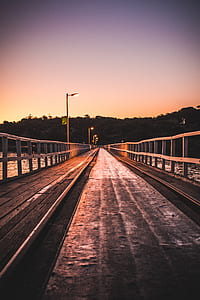 person showing brown wooden bridge in front of trees thumbnail