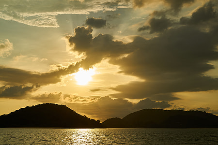 silhouette photography of mountain near body of water thumbnail