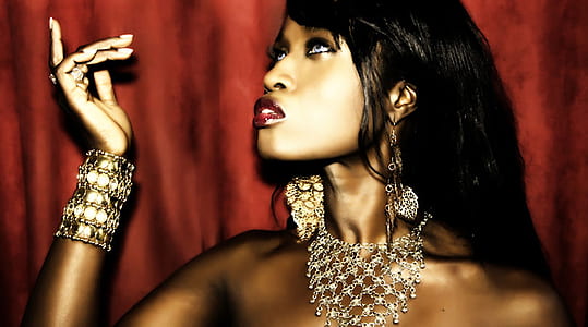woman wearing silver-colored jewelries near red surface thumbnail