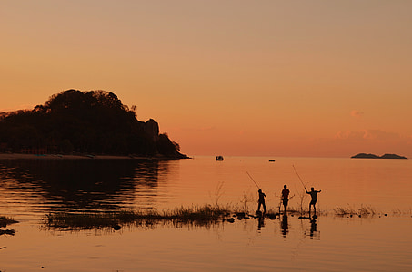 silhouette of three men fishing during golden hour thumbnail