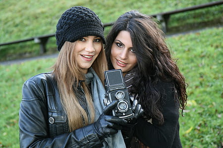 photography of two women holding camera thumbnail