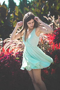 woman posing near red plants thumbnail