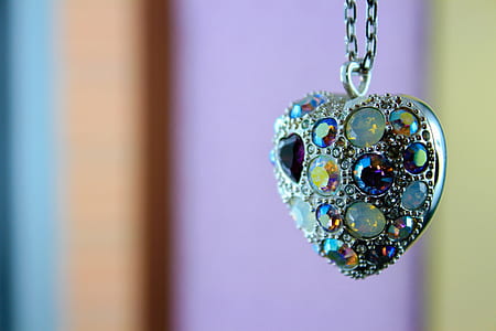 selective focus photo of silver-colored gemstone encrusted heart pendant thumbnail