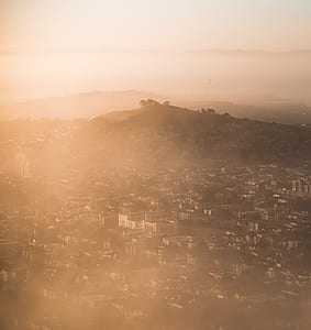 aerial view of houses and mountains under gray sky thumbnail
