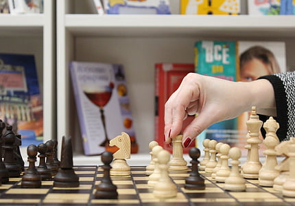 woman about to move chess rook thumbnail