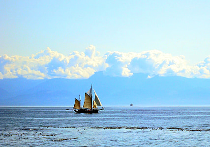 black and brown boat on sea near mountain thumbnail