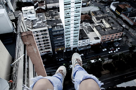 person sitting on ledge near buildings thumbnail
