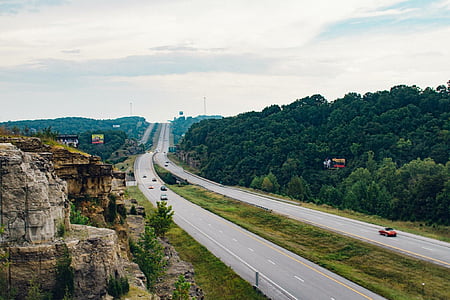 cars on road near mountain range thumbnail