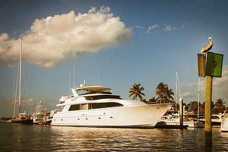 yacht docked near boats during daytime thumbnail
