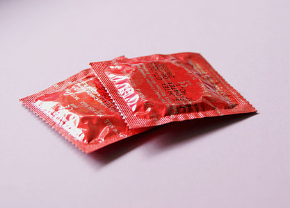 two red condom packs on white surface thumbnail