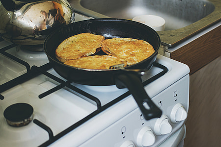 black frying pan on white gas stove thumbnail