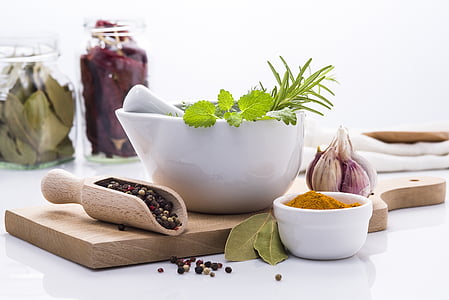 white ceramic mortar and pestle on brown wooden chopping board thumbnail