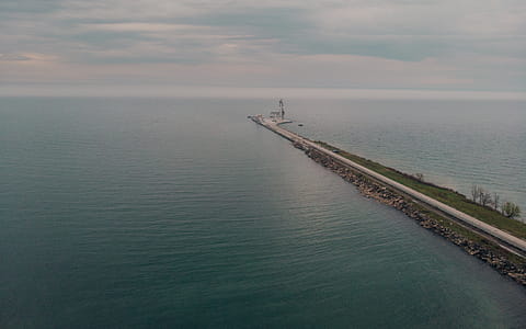 Aerial view of a road leading to a large seaport with horizon in the background thumbnail