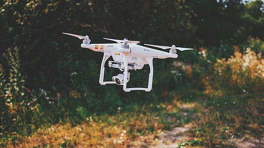 white Dji Phantom 3 drone flying above gras s thumbnail
