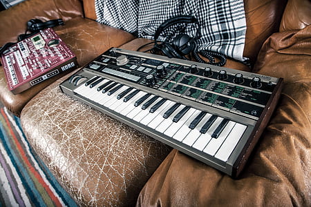 silver and white electronic keyboard on sofa thumbnail